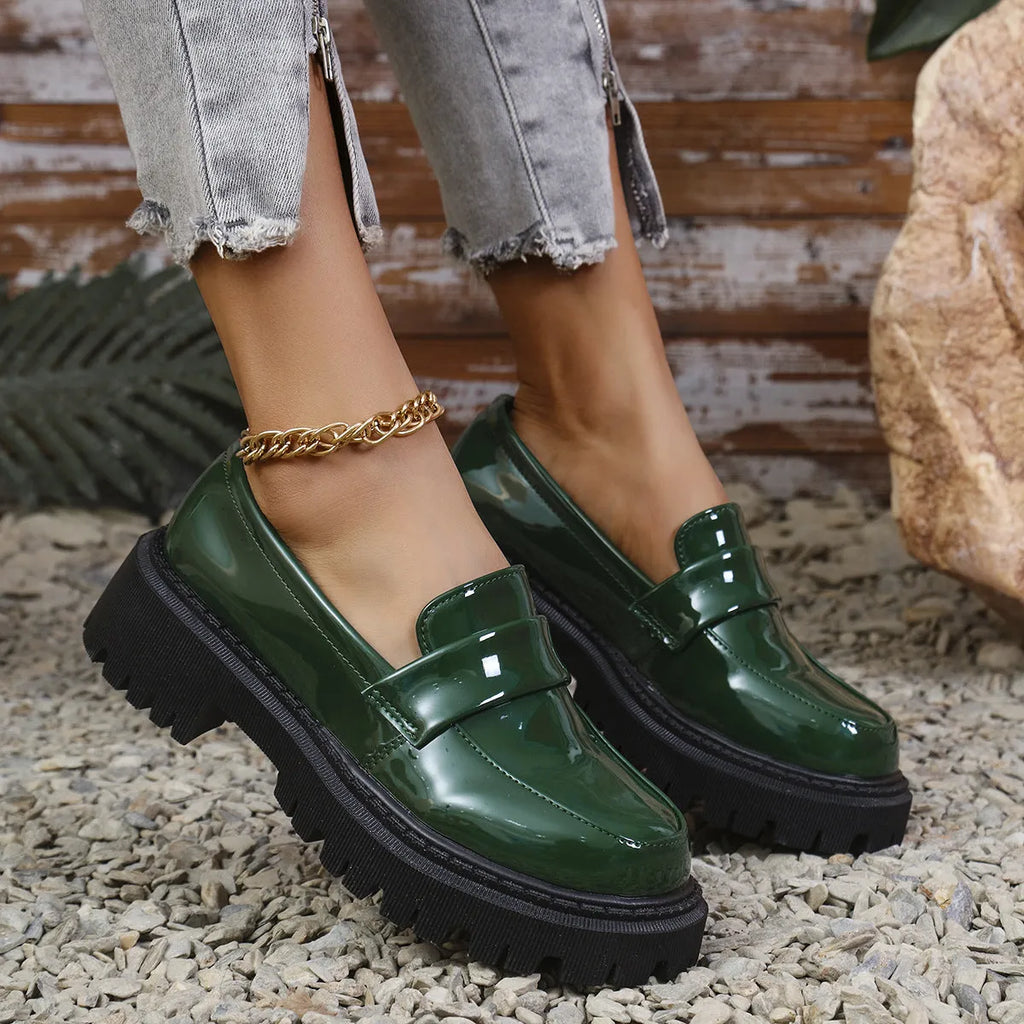 Plus size women's black slip-on loafers with a chunky platform heel and rubber sole.