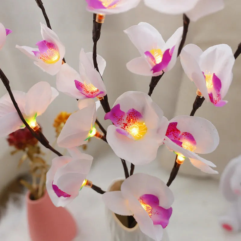 Pink LED phalaenopsis orchid branch decorative light on a table.