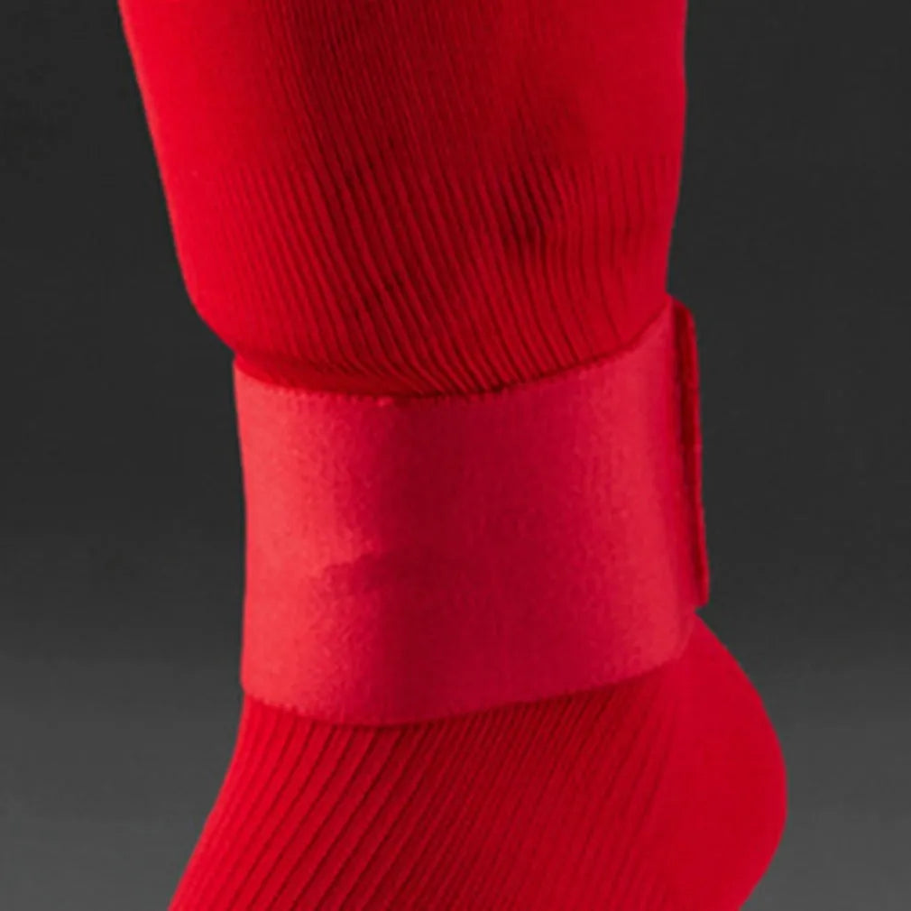 Red elastic rubber strap for securing football shin guards, shown at approximate size.
