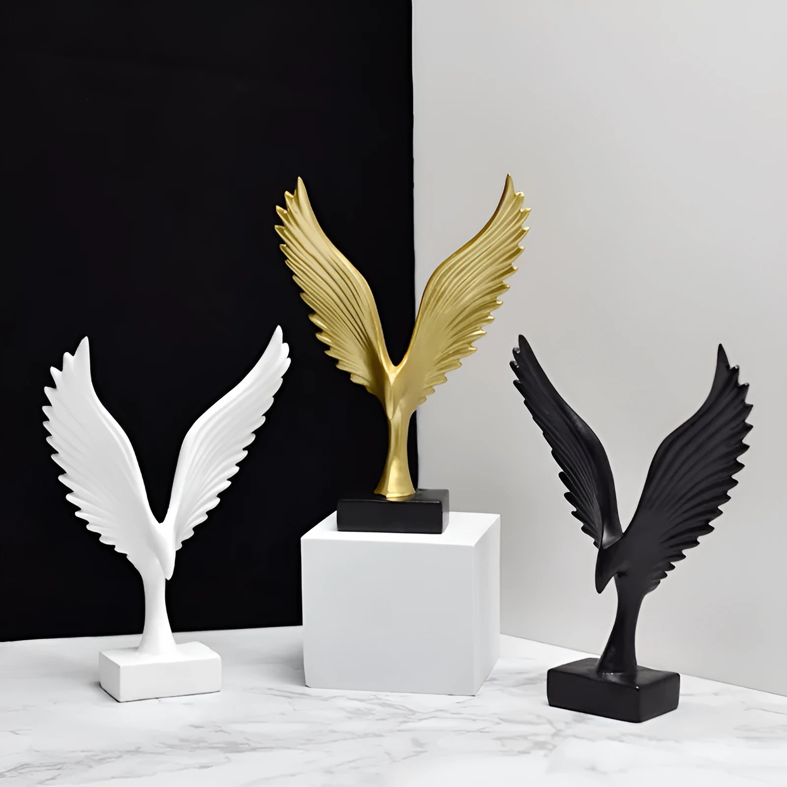 Mini synthetic resin decoration in silver and gold angel wing style on a shelf