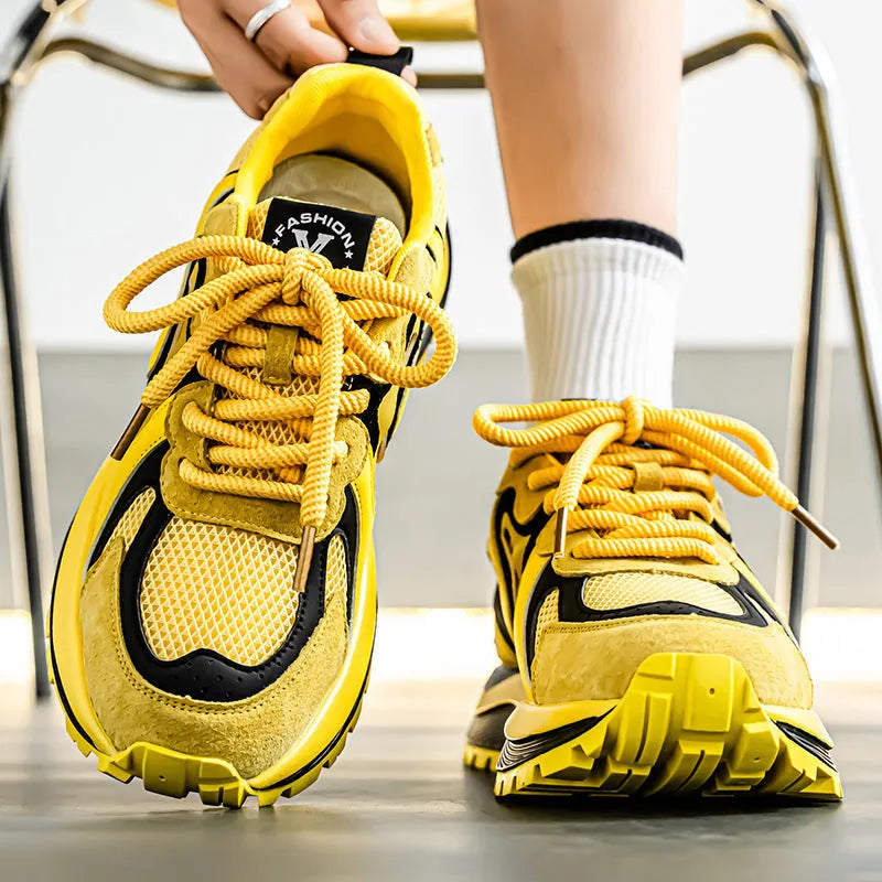 Men's yellow, black, and white mesh and synthetic leather casual sneakers with round toe and lace-up front.