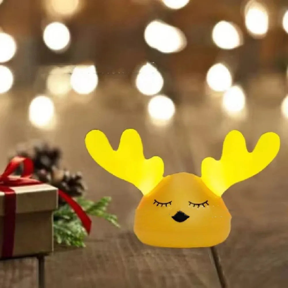 Children bedside Christmas deer night light with colour-changing LED and soft silicone shade on a table