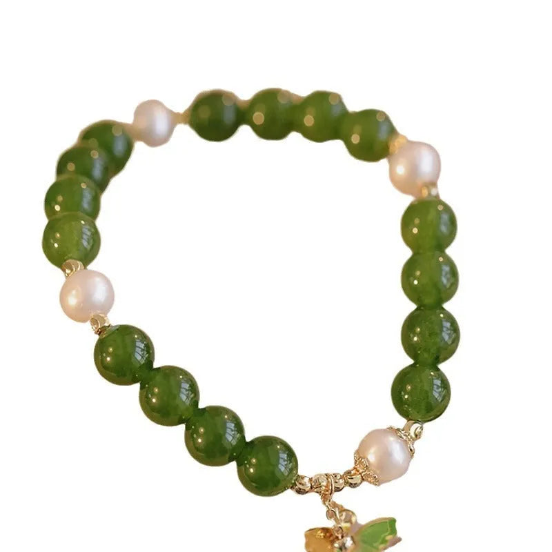 Natural green chalcedony bracelet with round geometric beads on a wrist.
