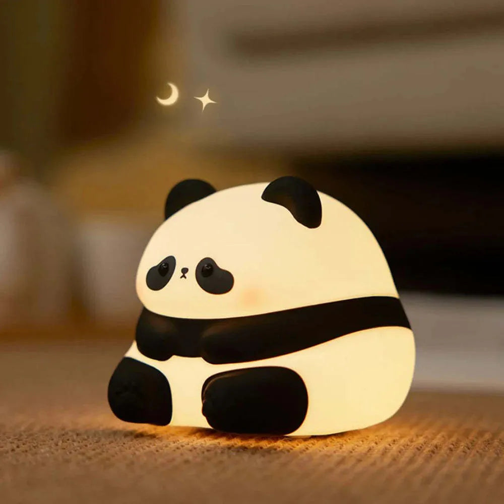 Cute cartoon panda-shaped silicone night light sitting on a surface, showing its soft glow.