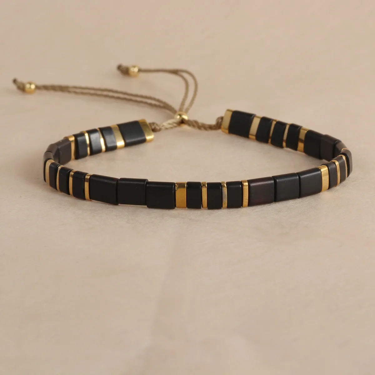 Geometric round glass bead bracelet in five colour options on a wrist.