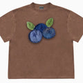 A loose-fitting blueberry and floral patchwork short sleeve t-shirt on a hanger.