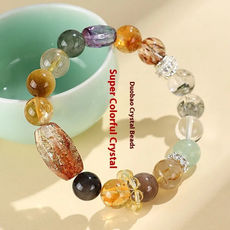 Close-up of a women's black and gold bracelet with natural Super Seven Duobao crystal beads.