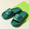 Pair of thick-soled EVA flip-flop slippers in a chosen colour on a bathroom floor.