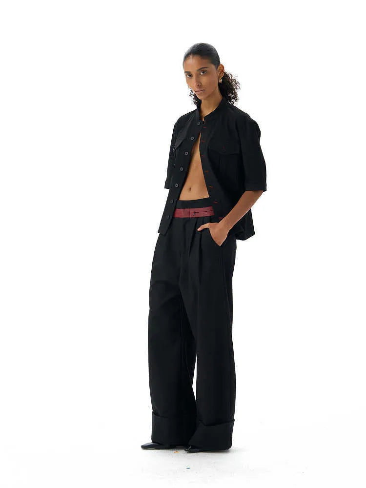 Black handmade loose-fit half sleeve hunting shirt with a shirt collar on a hanger.