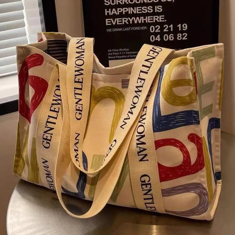 Large canvas women's travel tote bag with shoulder strap and printed design