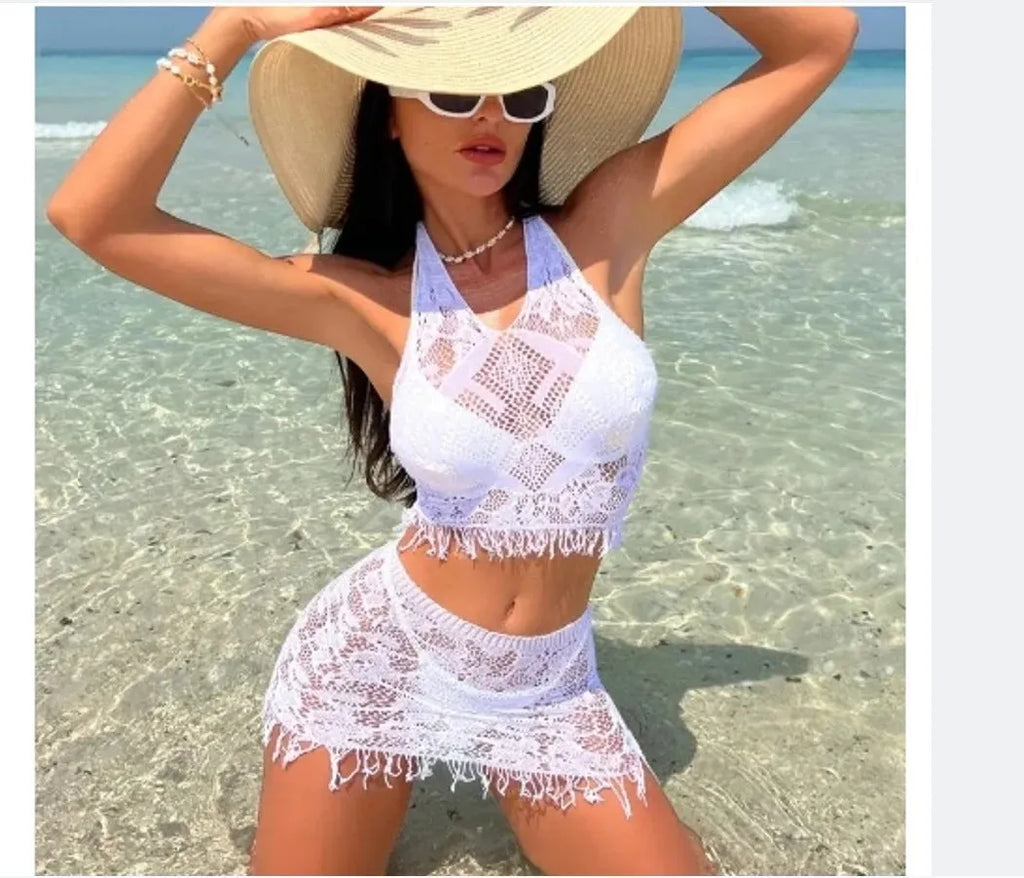 Women's white lace bikini top with matching tassel skirt two-piece swimsuit set on beach