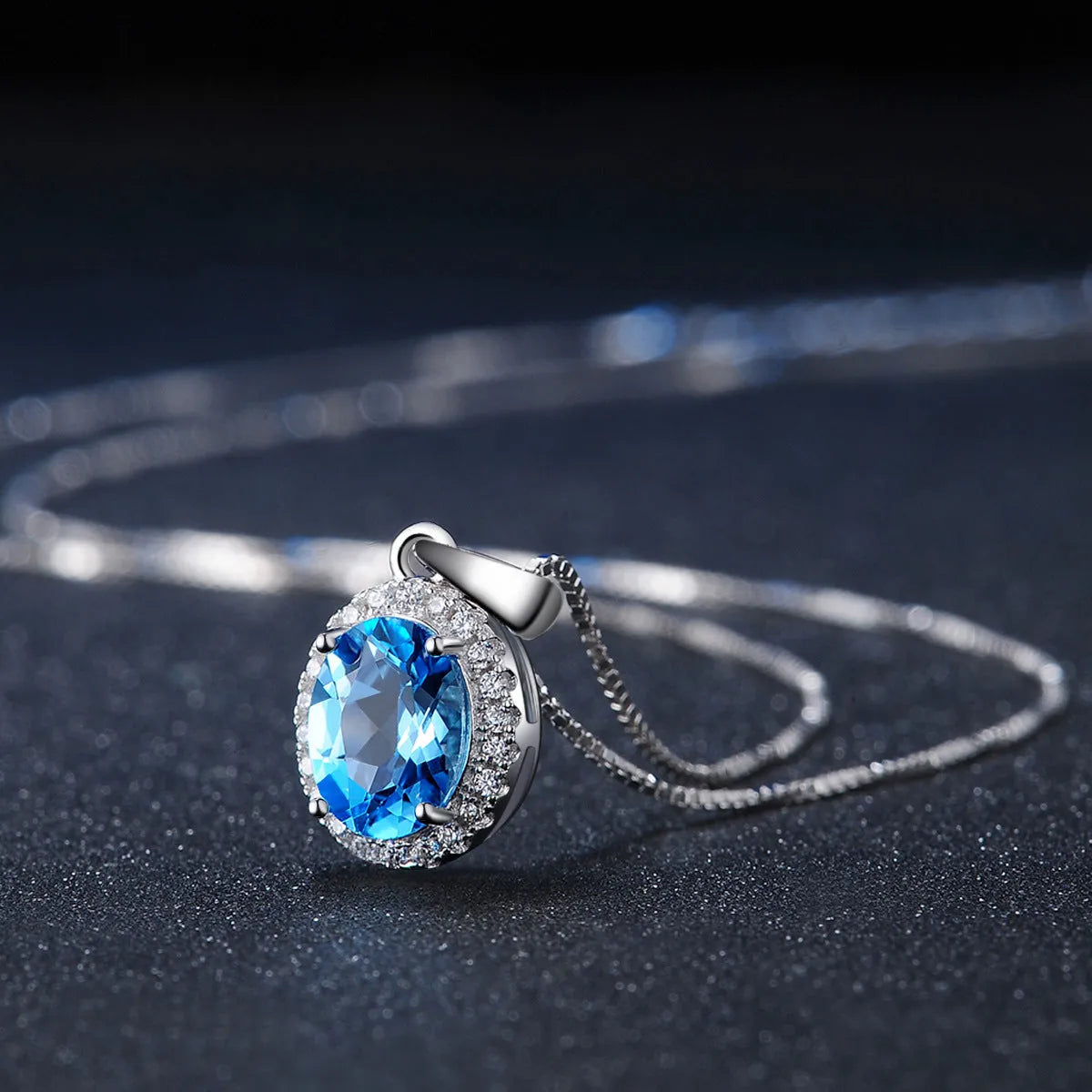 Four-piece sterling silver jewellery set with blue topaz: geometric earrings, ring, pendant, and necklace.
