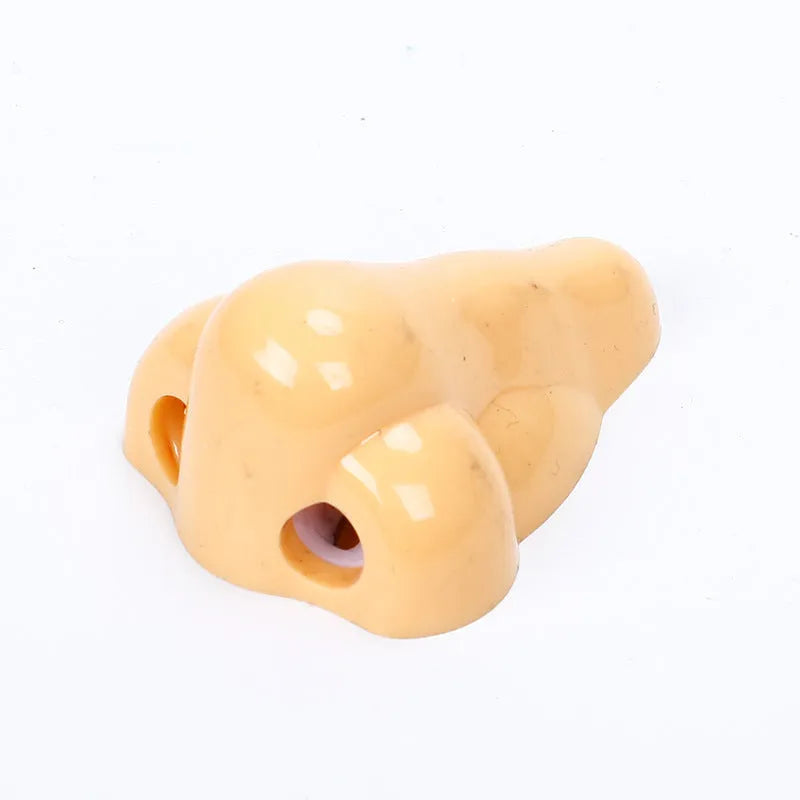 Flesh colour plastic manual pencil sharpener with big nostril hole on geometric body.