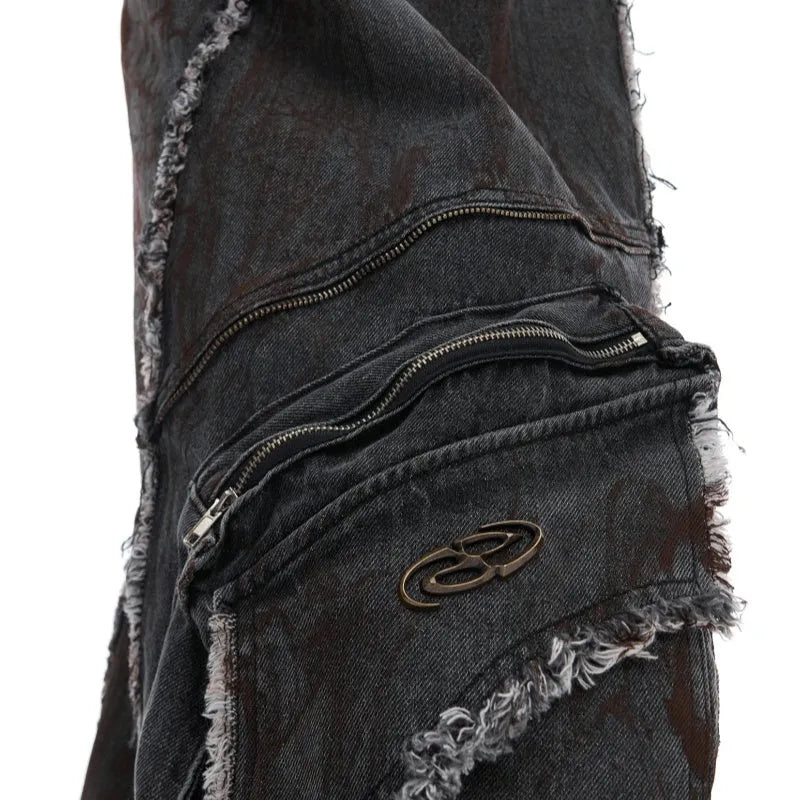 Black distressed raw-edge denim coat with padded shoulders and splash-dye gradient, paired with matching black pants.