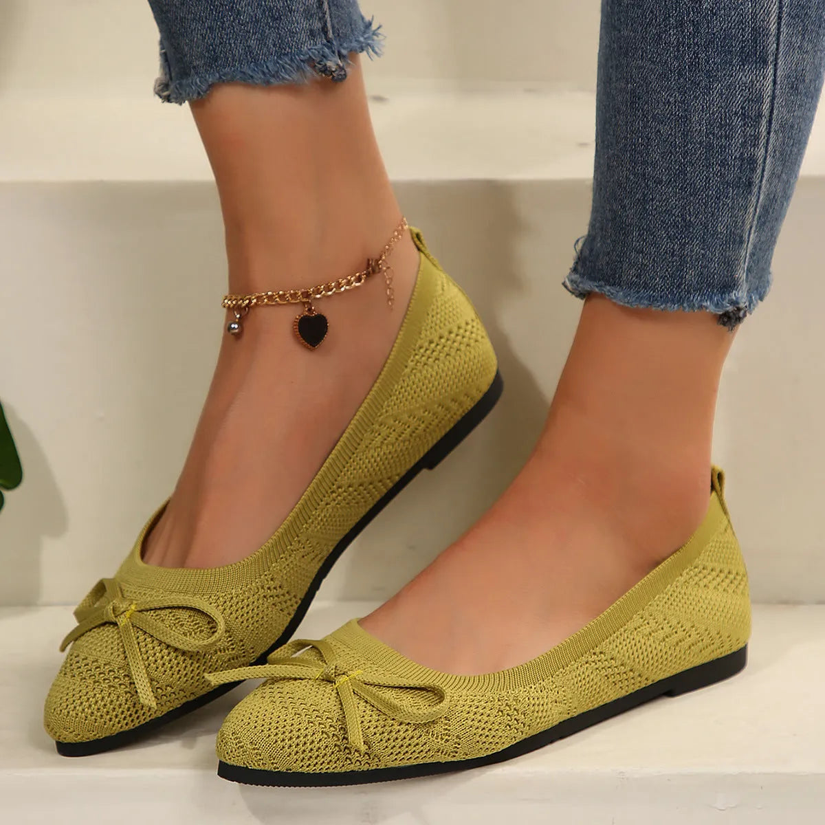 Women's blue knitted flat loafers with a bow and pointed toe on a rubber sole.