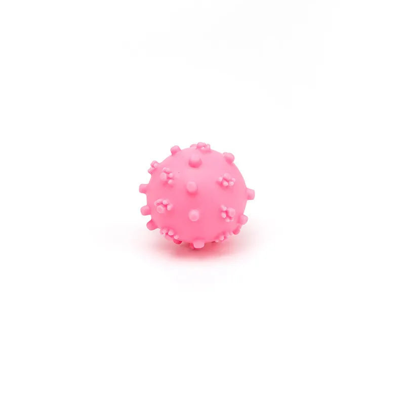 Bright blue, green, pink, and yellow squeaky dog toy balls with a spiky texture and paw print dimples.