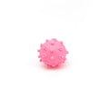 Bright blue, green, pink, and yellow squeaky dog toy balls with a spiky texture and paw print dimples.