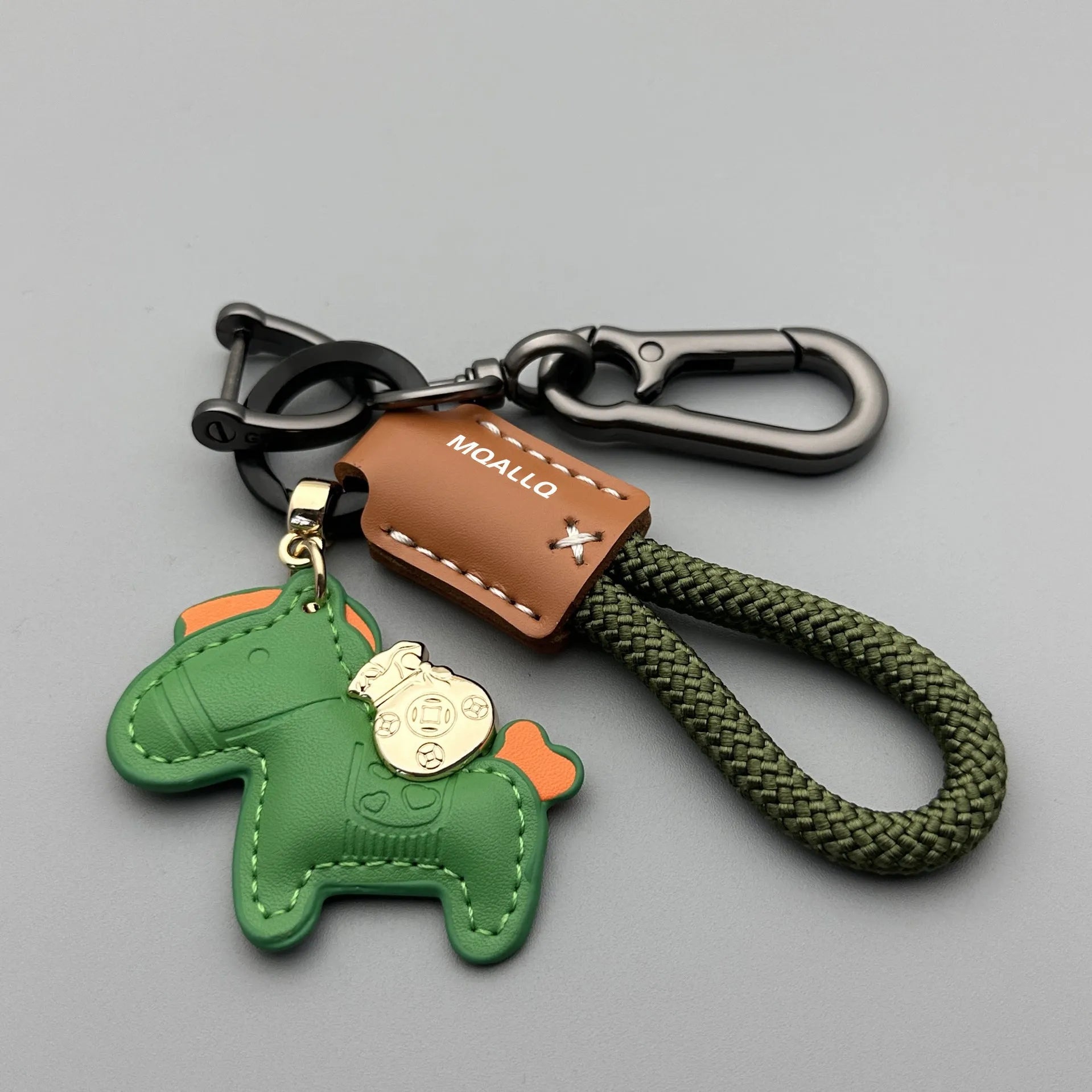 Handmade brown cowhide leather keychain with a zinc alloy pony belt buckle on a green flanelle rope.