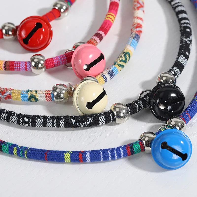 Coloured ethnic pattern adjustable pet collar with metal bell and D-ring on a nylon strap.