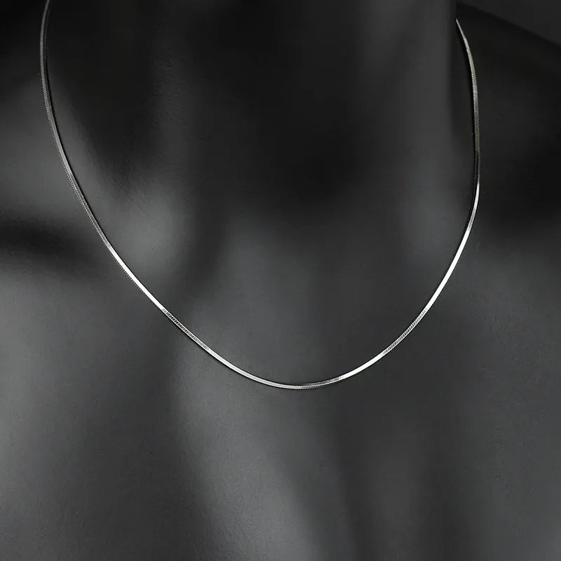 S925 sterling silver plated platinum necklace with fine snake bone chain in silver on neutral background