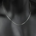 S925 sterling silver plated platinum necklace with fine snake bone chain in silver on neutral background