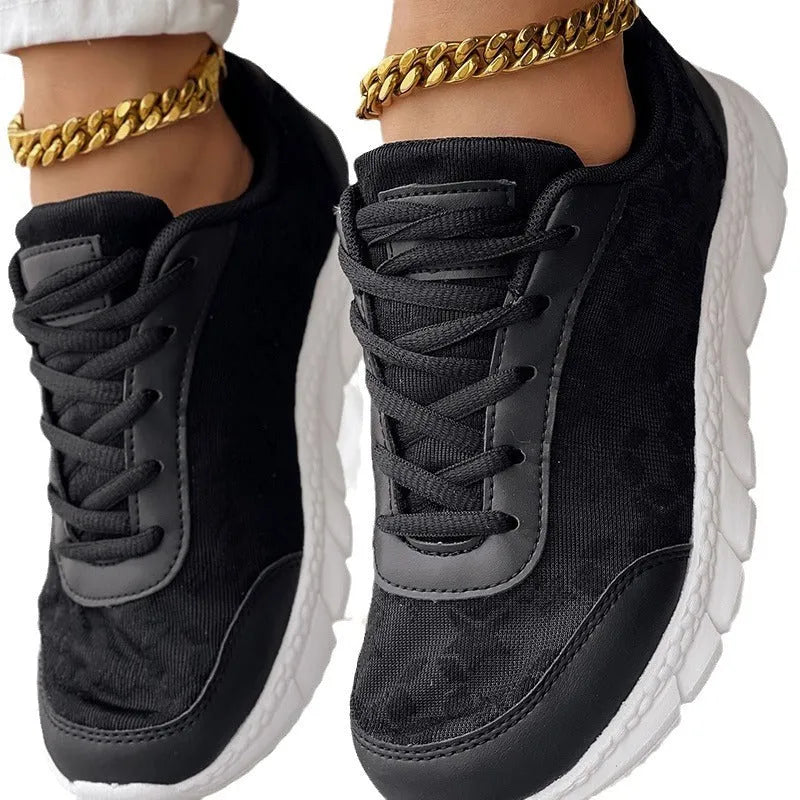 Women's white canvas running shoes with flat heel and round toe design on neutral background