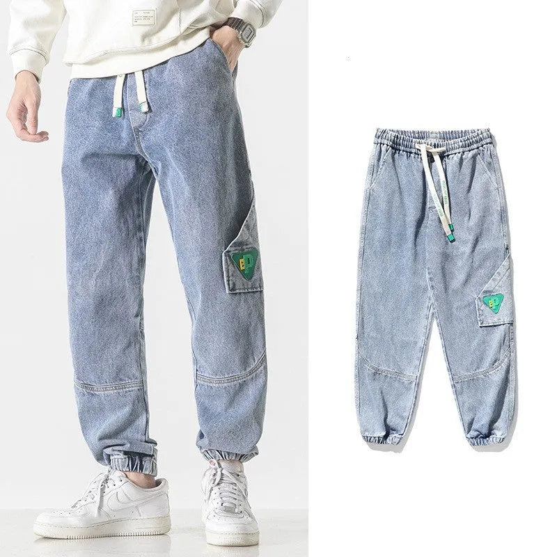 Men's black cotton loose-fit tapered trousers with a mid waist on a hanger.