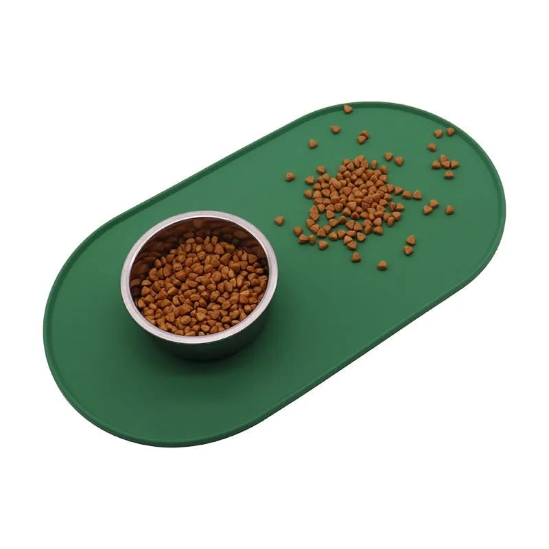 Silicone waterproof cat feeding placemat in beige colour on a floor next to a food bowl.