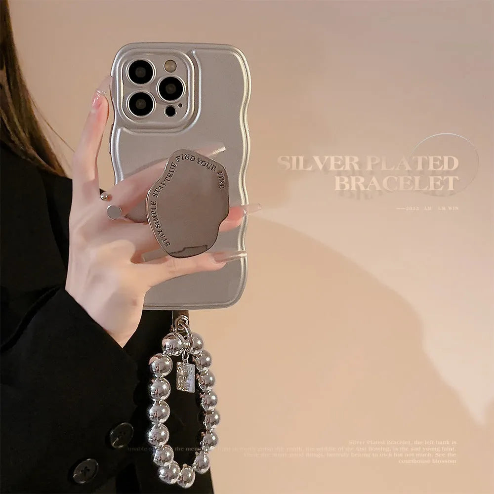 Silver metal bracket phone case for iPhone with electroplated finish and hand bead detail on gray background