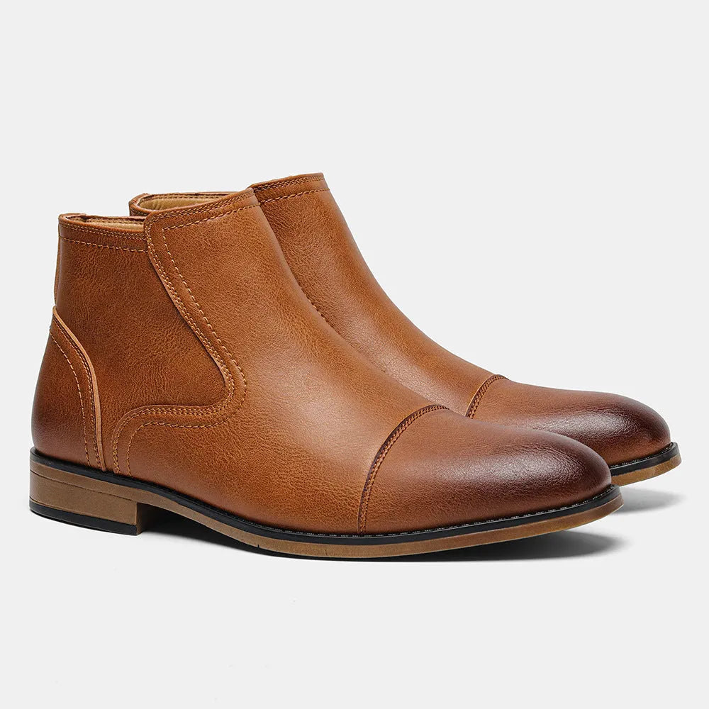 Men's black Chelsea boots with a side zipper, round toe, and low heel on a wooden sole.