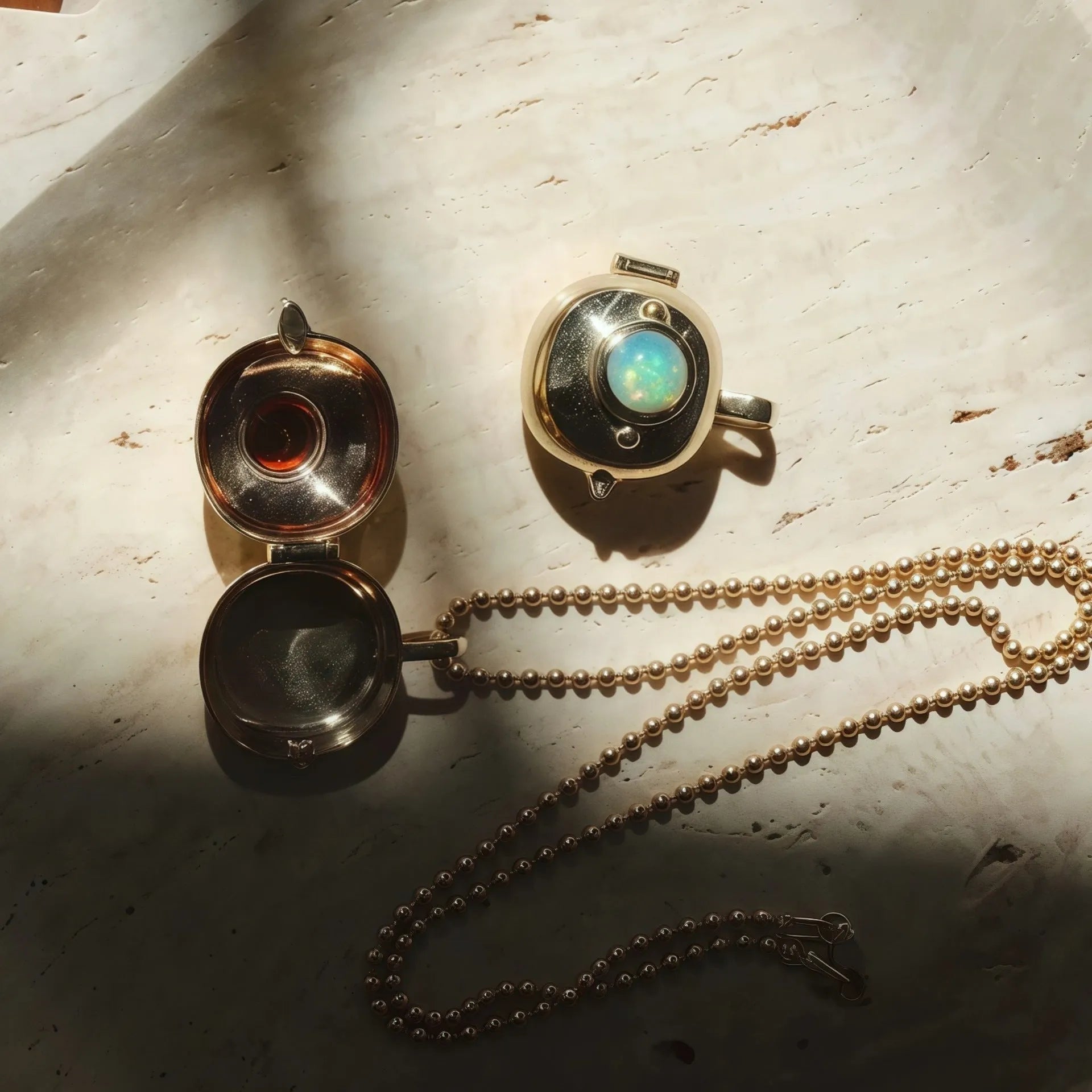 Gold-plated copper teapot pendant necklace with round red gemstone accent on regular chain, opened to show storage compartment