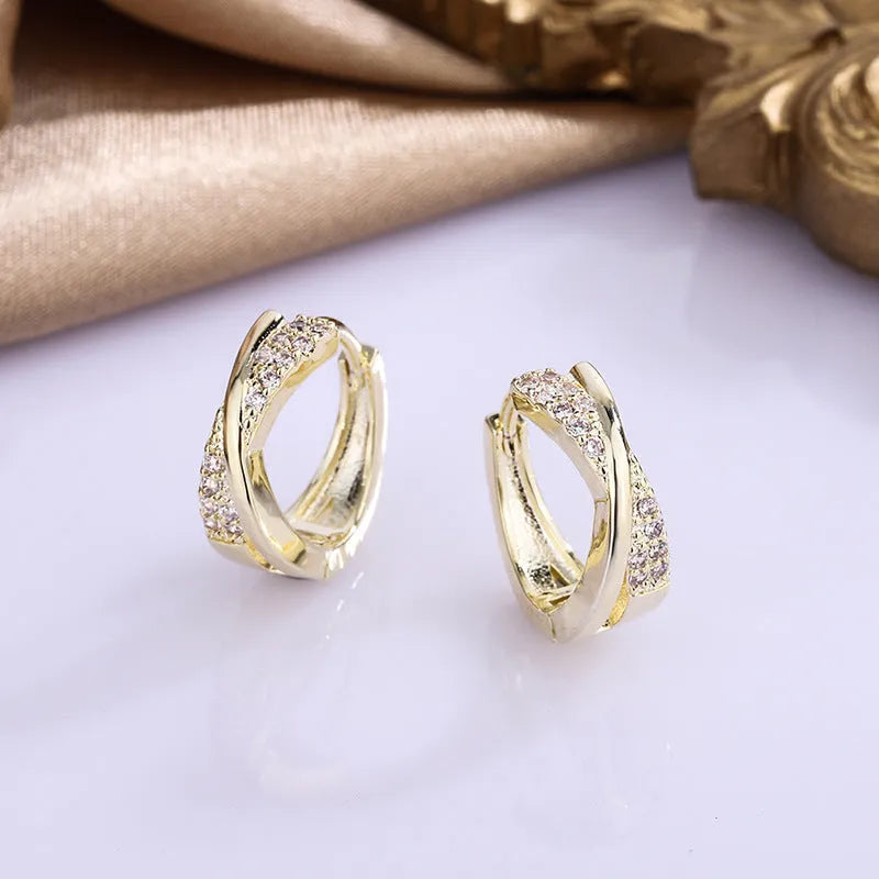 Geometric shaped women's earrings with 14K yellow gold plating and zircon stone details on a copper base.