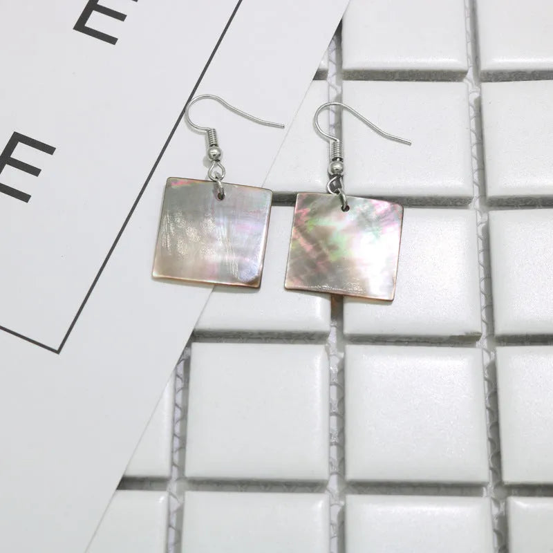 Women's geometric shell earrings showing rectangular and square shapes with natural shell material texture
