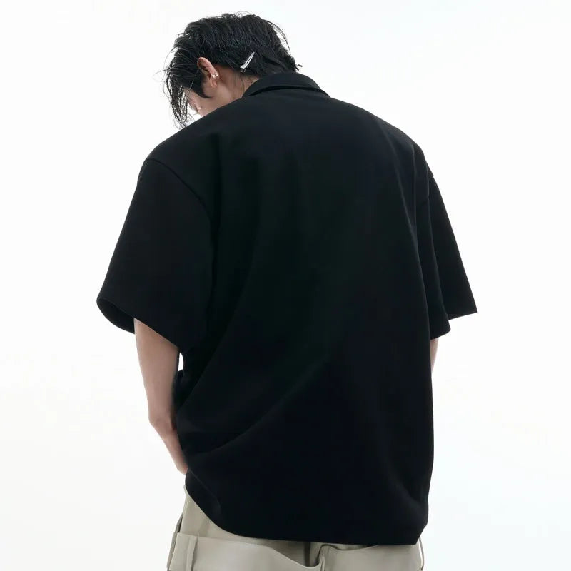 Men's black geometric print polo shirt with a deconstructed layered collar design.