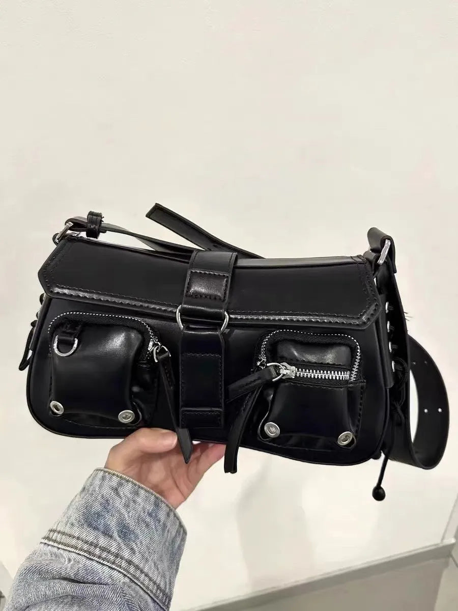 Black women's underarm baguette messenger bag with single shoulder strap showing interior zipper pocket