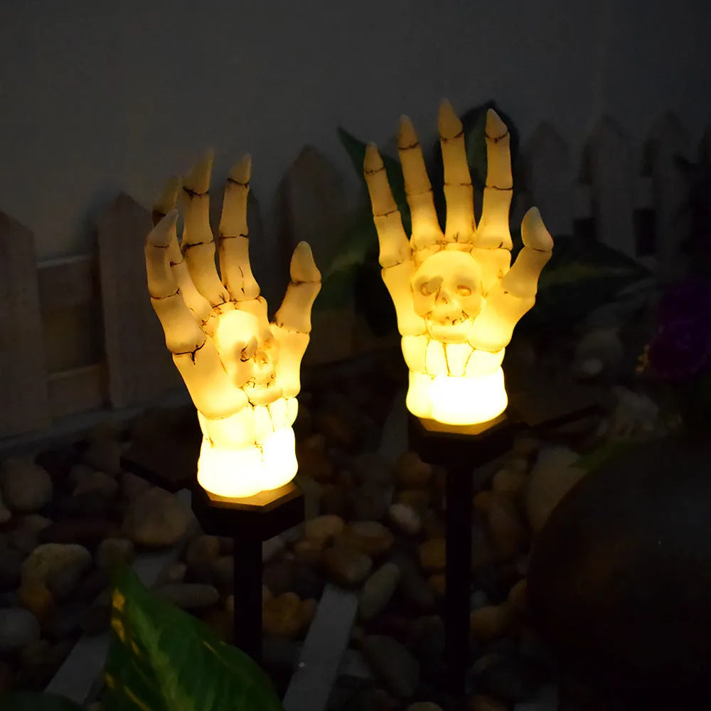 Halloween ghost hand solar light in garden setting with warm white glow, plastic IP55 waterproof construction