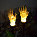 Halloween ghost hand solar light in garden setting with warm white glow, plastic IP55 waterproof construction