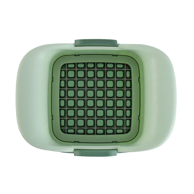 Green multifunctional vegetable chopper with stainless steel blades for dicing onions and slicing cucumbers.