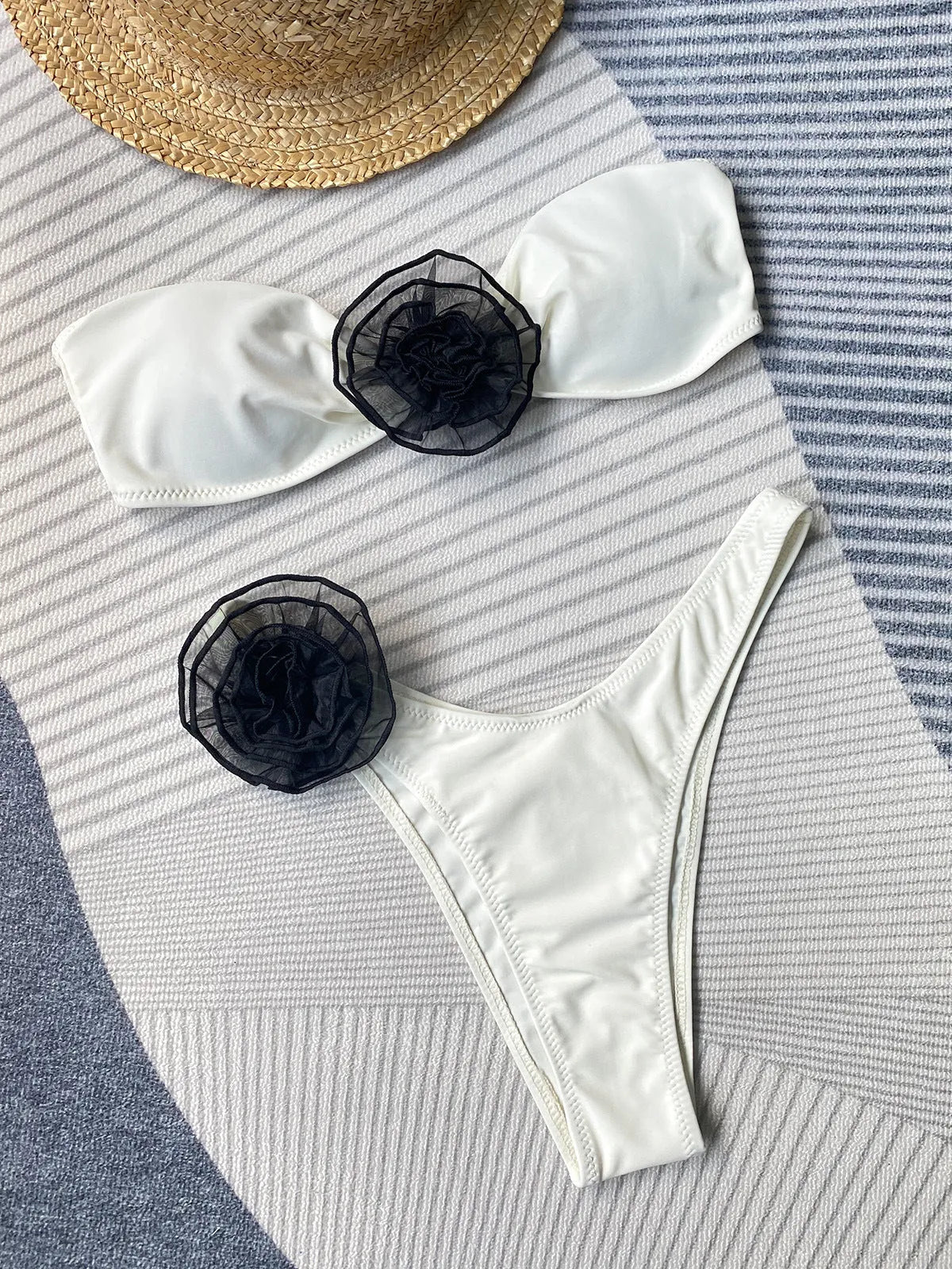 Black and white striped bikini swimsuit with tube top and three-dimensional floral split detail on the shorts.