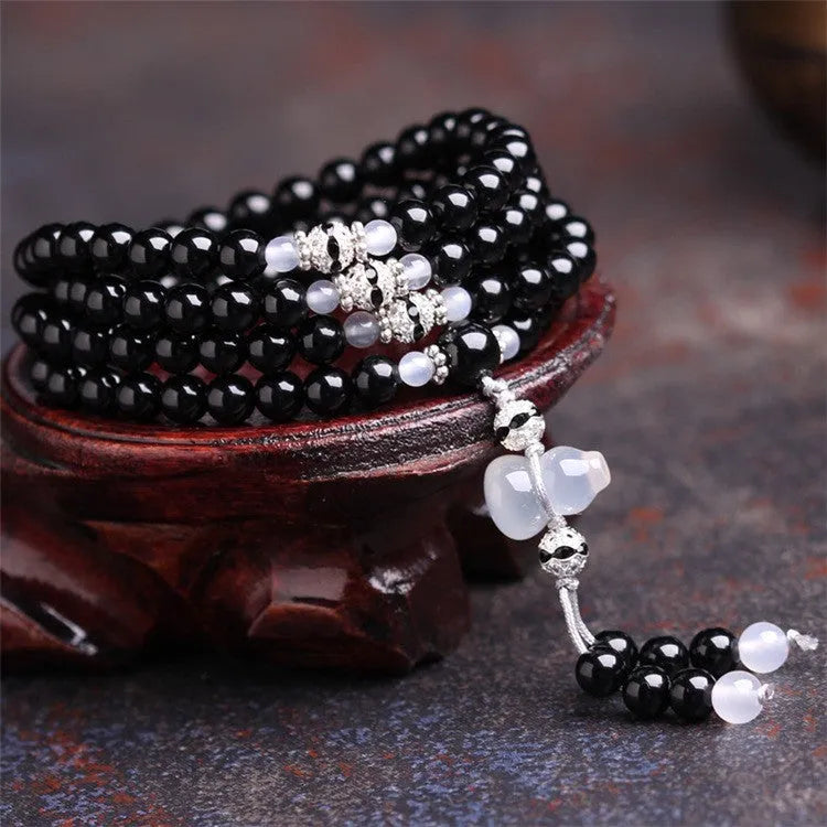 Natural black agate bracelet with 108 beads showing geometric shapes and numeric design elements