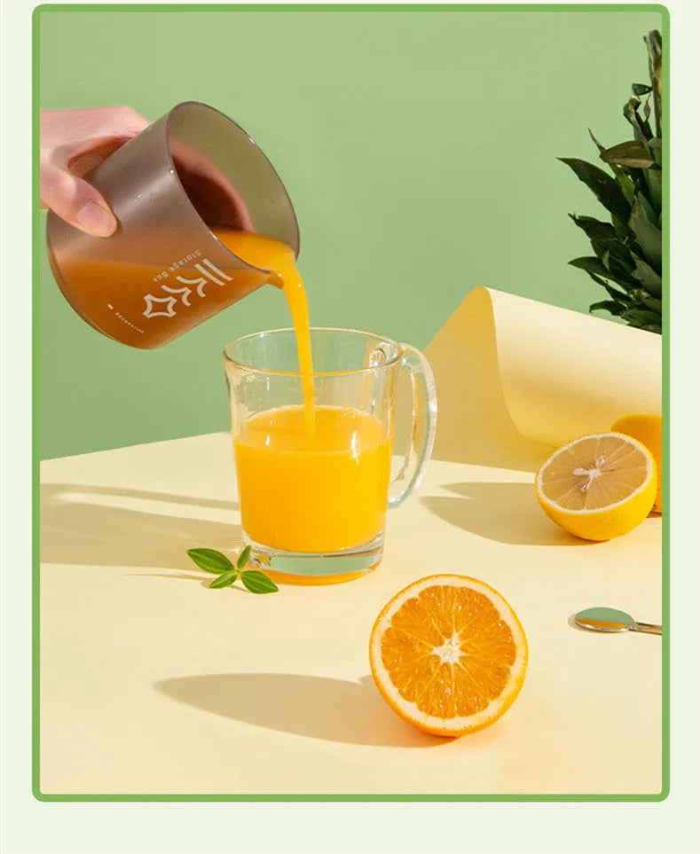 Green manual citrus juicer with lid on a kitchen countertop