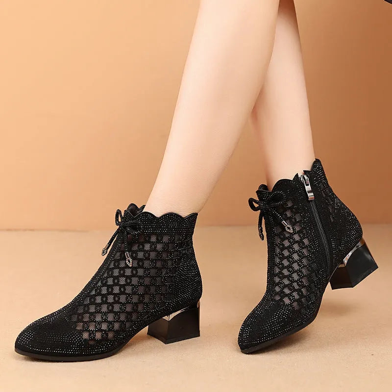 Women's black cutout mesh ankle boots with mid heel and rhinestone trim, side zipper closure