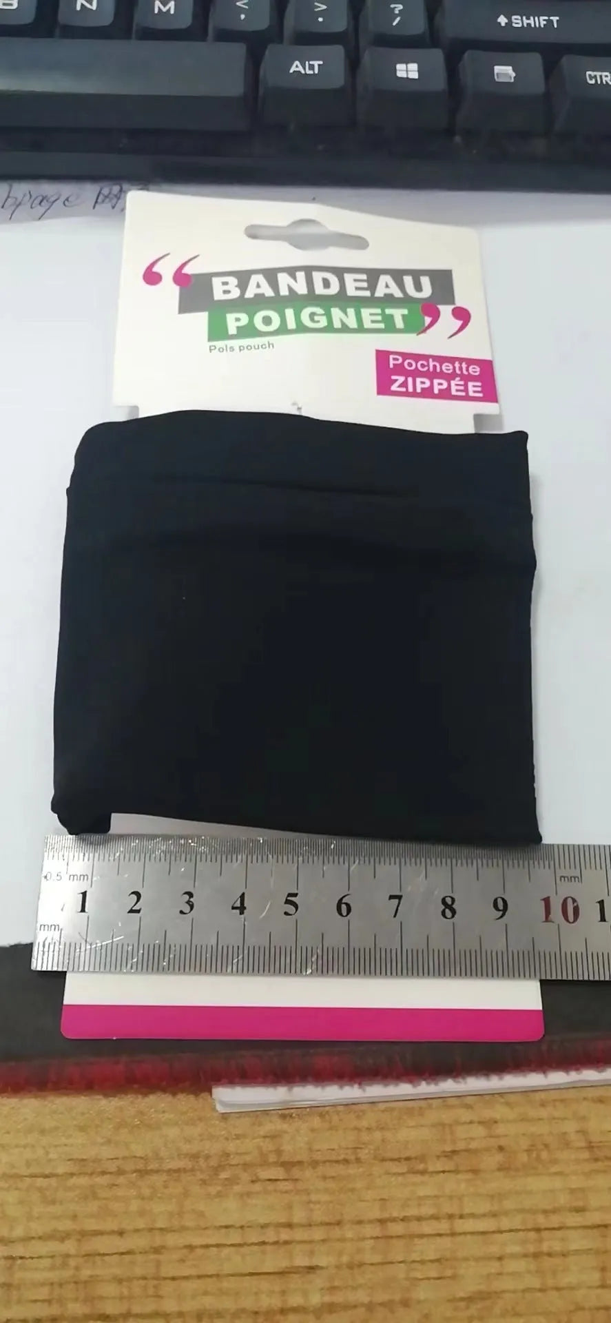 Black waterproof polyester wrist armband sleeve for mobile phone, shown on a forearm.