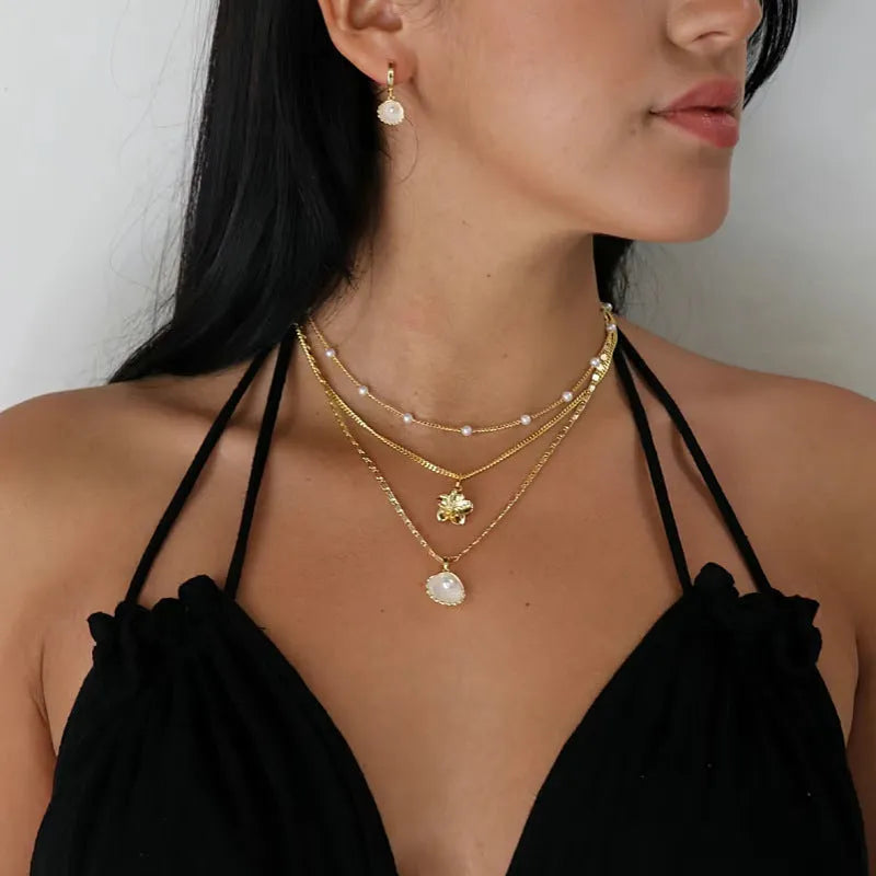 Pearl necklace with copper geometric pendant and ball bead chain on dark background