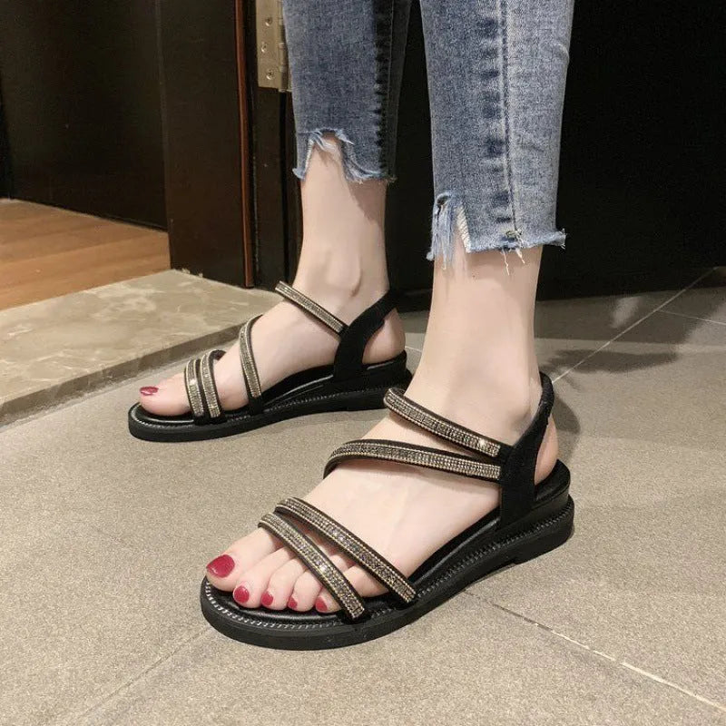 Gold women's flat sandals with sequin decoration and an elastic band, shown on a white background.
