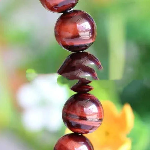 Red tigereye wooden bracelet with geometric bead design showing lightning eye reserva colour stone details