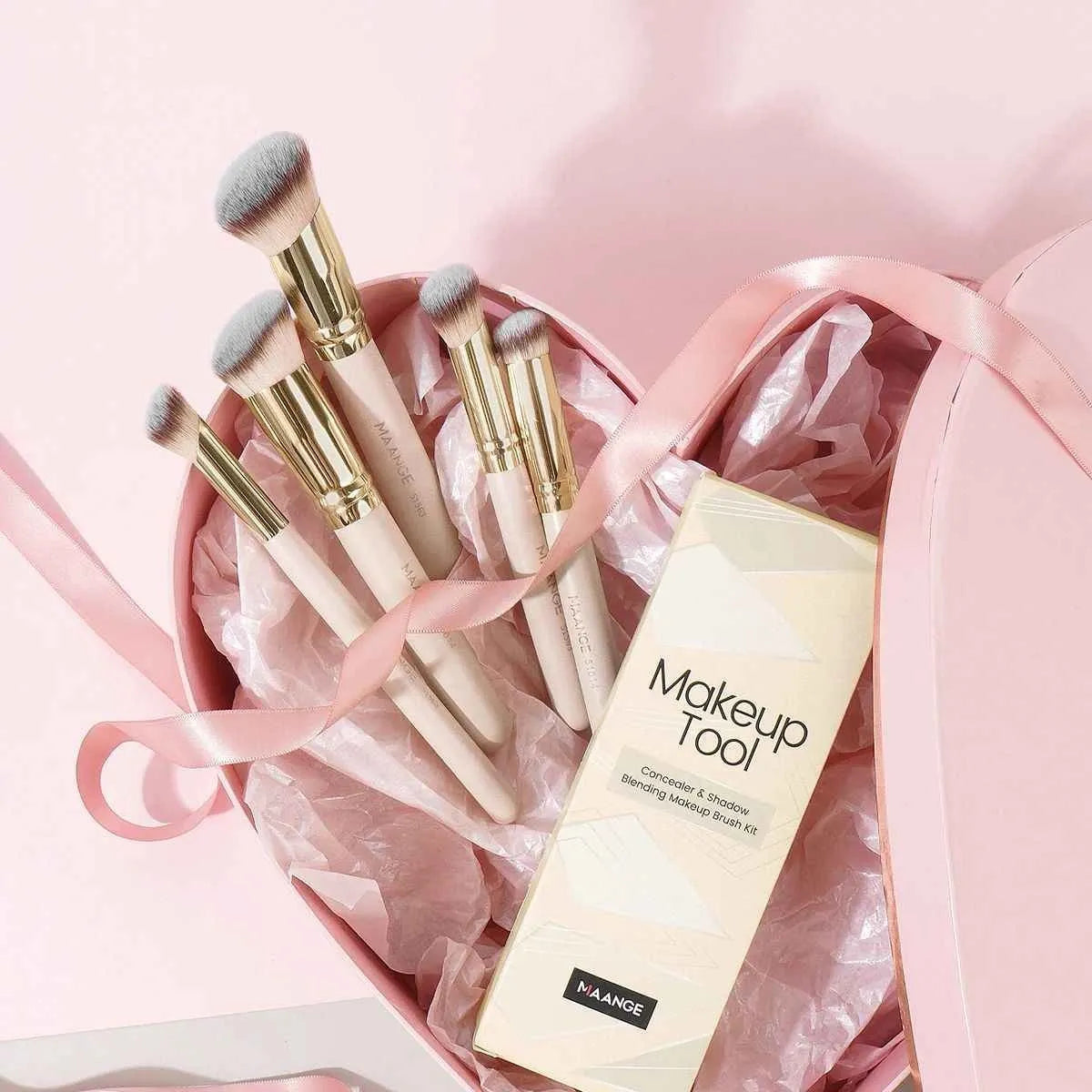MAANGE apricot-coloured angled blush brush and four other makeup brushes on a table.