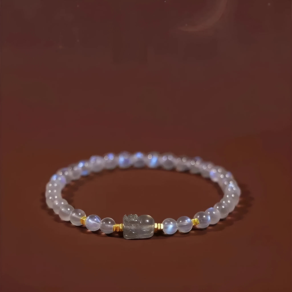 Close-up of a moonstone bracelet with a carved animal or zodiac design, showing grinding finish and blue light trend detail.