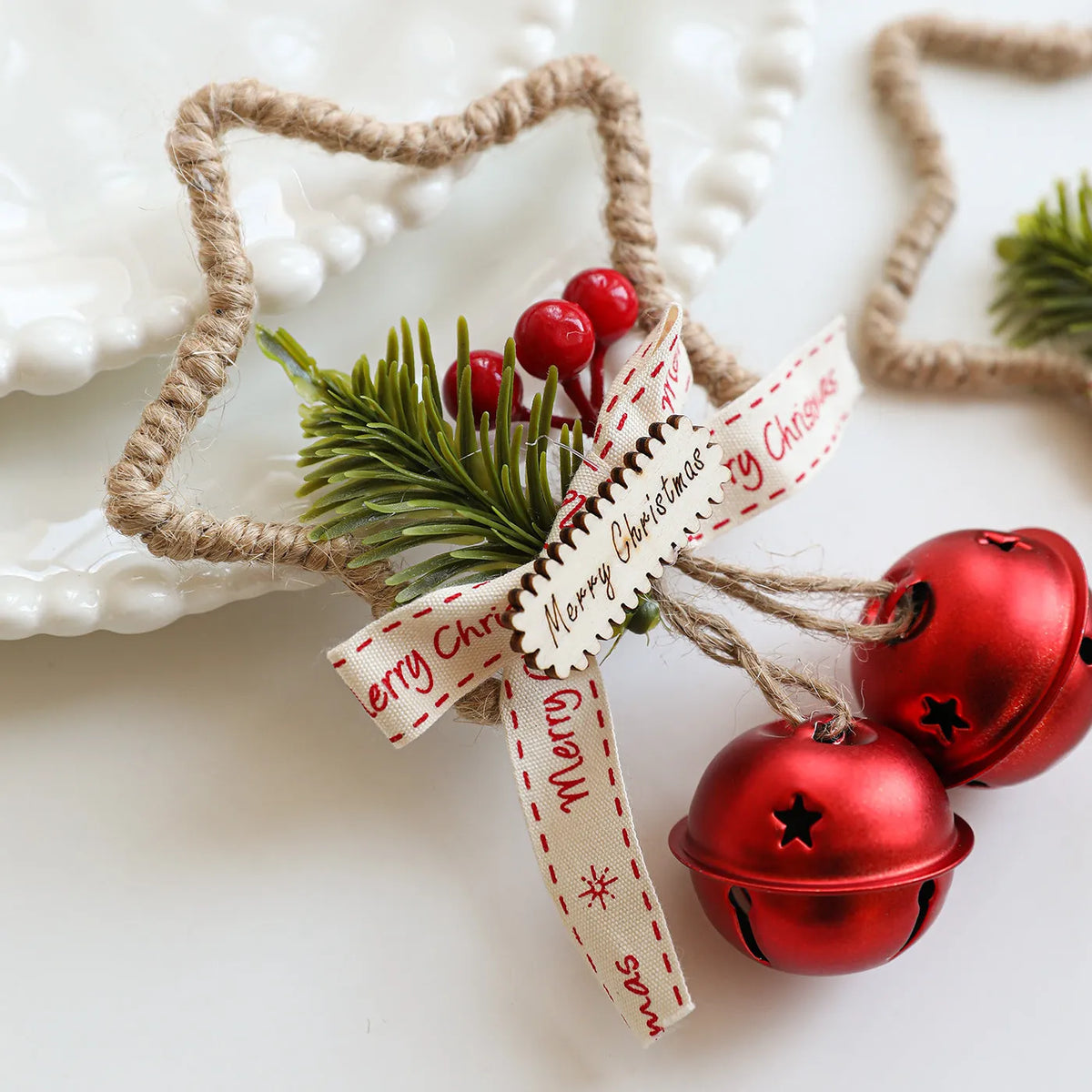 Iron Christmas bell ornament in gold hanging on a Christmas tree branch