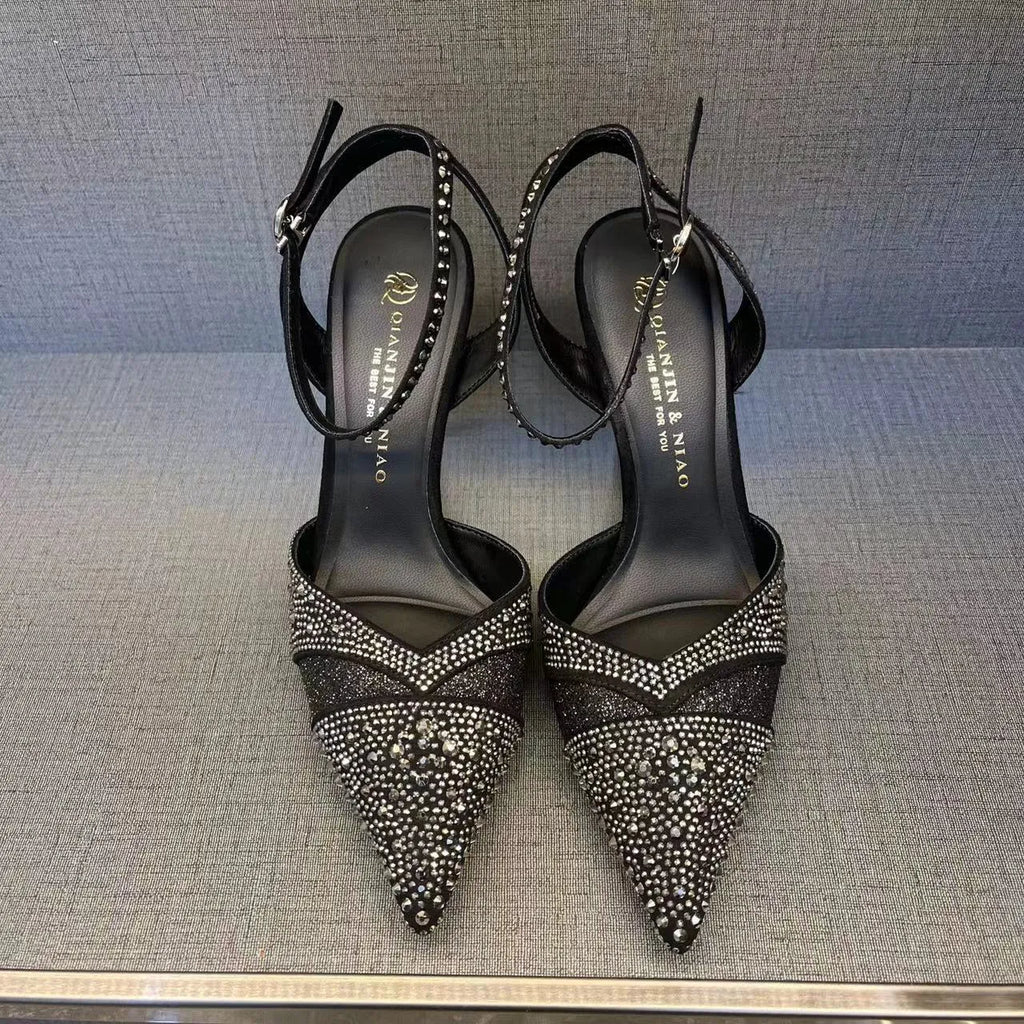 A pair of women's black hollow high heels with a red sole, stiletto heel, and pointed toe.